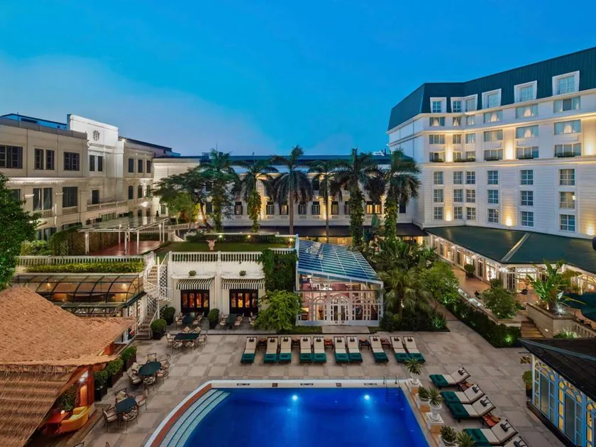 La piscine et les bâtiments du Sofitel Legend Metropole, à Hanoï, au crépuscule