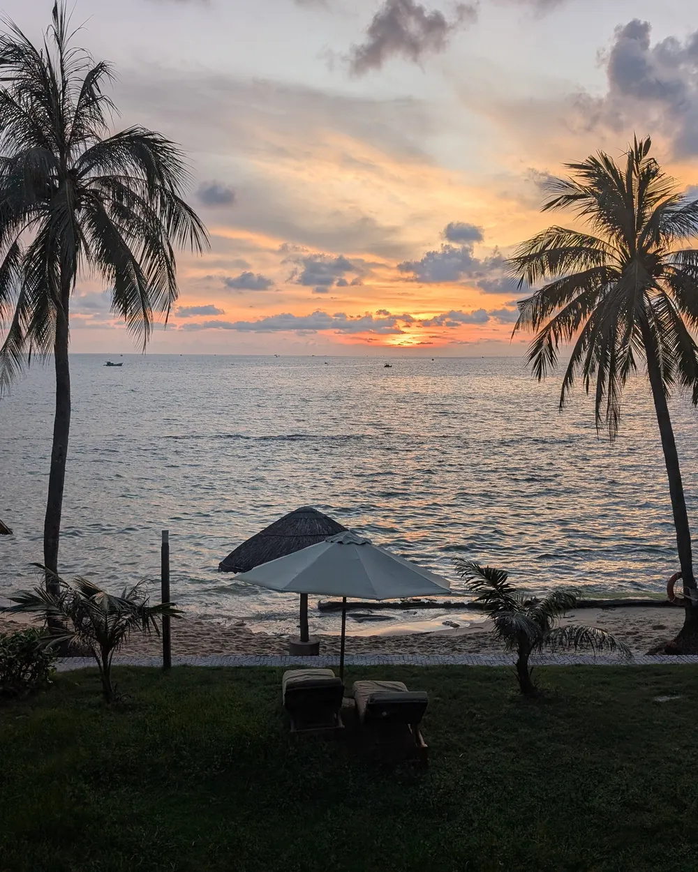 Le coucher du soleil sur la mer, entre les palmiers d'une plage de Phu Quoc